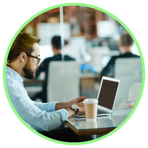 Businessman-working-on-laptop-in-crowded-office